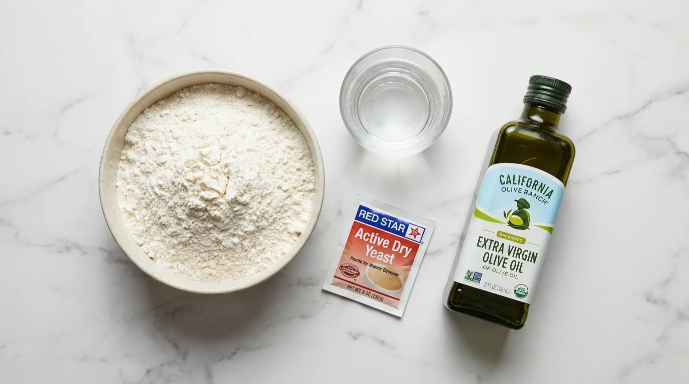 Ingredients for pizza dough arranged on a marble countertop